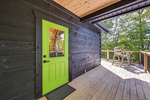 A wooden deck with a green door and a wooden railing.