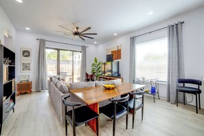 A modern living room with a dining area, a ceiling fan, and a TV. - Community Boat Ramp! Family Escape w/ Fenced Yard (Granbury)