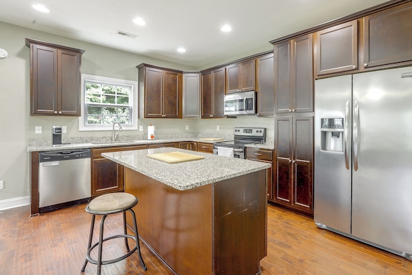 A kitchen with wooden cabinets, stainless steel appliances, a granite countertop, and a window. - Entire Home in Chesapeake, Virginia (Chesapeake)