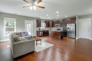 A spacious living room with a gray sofa, a coffee table, and a patterned rug. - Entire Home in Chesapeake, Virginia (Chesapeake)
