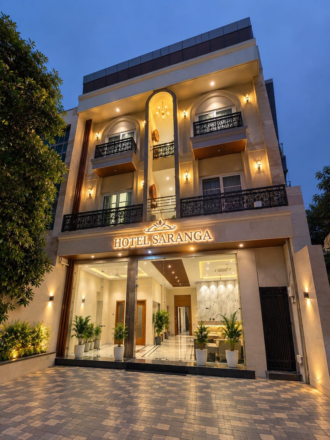 A hotel with a modern facade, multiple balconies, and a well-lit entrance.