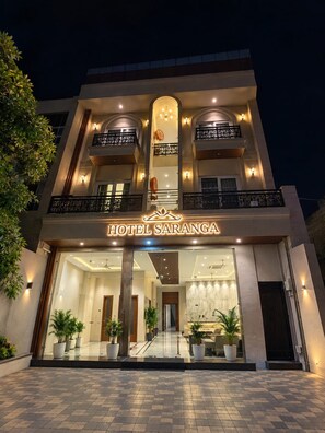 A multi-story hotel with a prominent entrance, balconies, and potted plants. - Hotel Saranga - Indore (Indore)