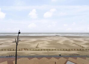 Ein Strand mit gepflastertem Weg und einer Umzäunung.