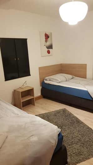 A bedroom with a bed, a desk, a chair, a wardrobe, and a painting on the wall. - Apartment Neugasse – Central Location in Zwingenberg, 3 Bedrooms, Up to 6 Guests (Zwingenberg)