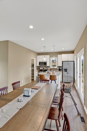 A modern kitchen with white cabinets, stainless steel appliances, and a central island.