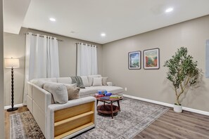 A living room with a sofa, a coffee table, a lamp, and a potted plant.