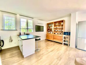Una cocina moderna con una isla central, armarios de madera y un horno empotrado.
