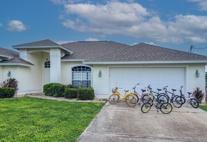 Ein Wohnhaus mit Garage, Auffahrt und einer Reihe von Fahrrädern, die davor abgestellt sind.