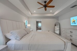 A bedroom with a bed, a ceiling fan, a dresser, and a mirror. - Cape Coral 3BR w/ Sun-Shelf Pool & Big Patio - Sleeps 6 (Cape Coral)