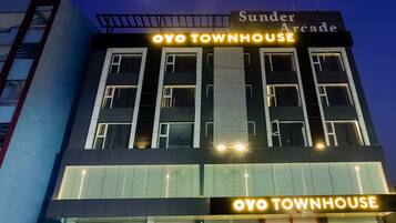 A building with a sign reading 'Sunder Arcade' and 'Oyo Townhouse' with a modern architectural design, featuring multiple windows and a visible balcony.