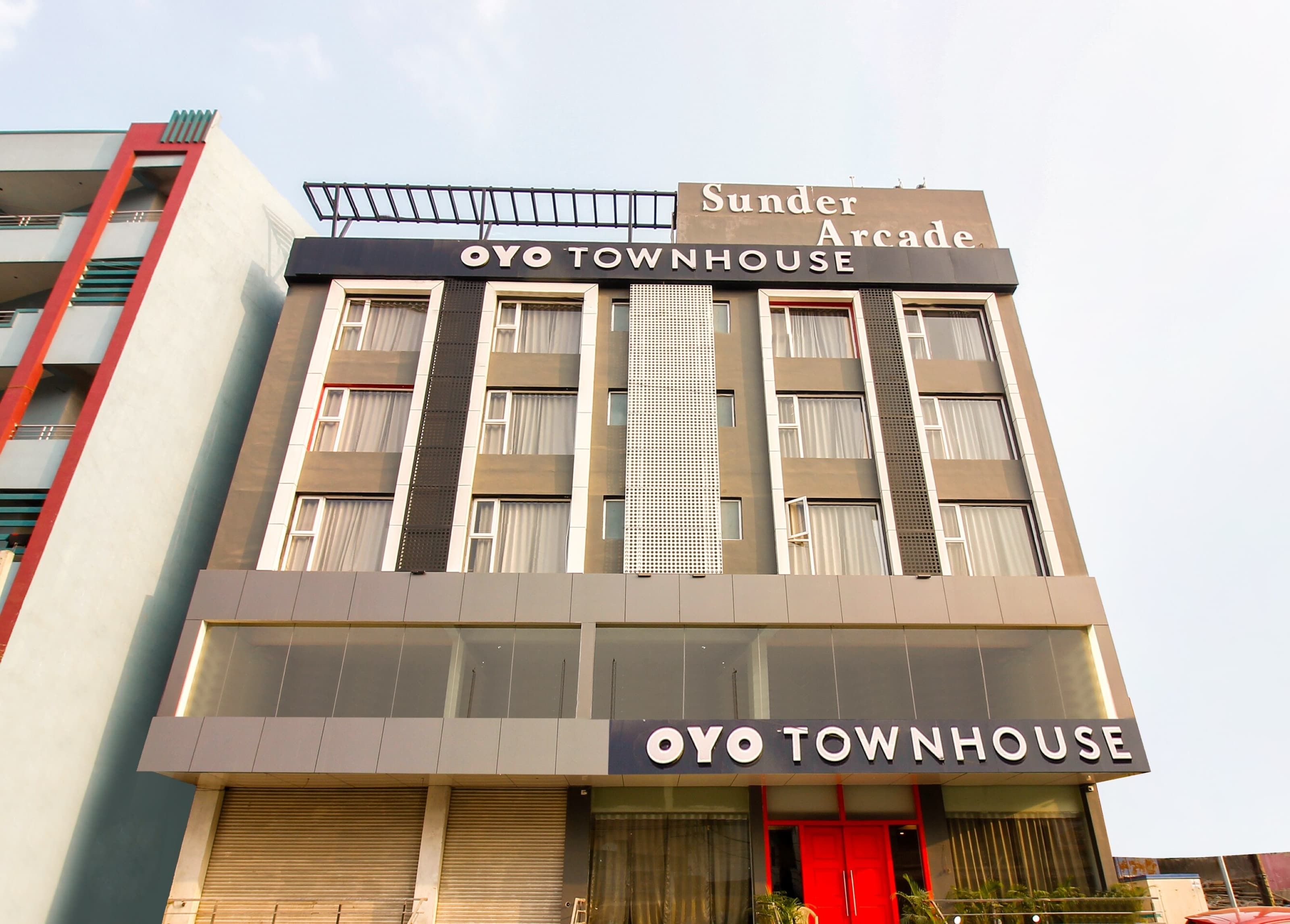 Um edifício com uma placa indicando 'Sunder Arcade' e 'OYO TOWNHOUSE', sinalizando um espaço comercial.