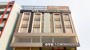 Um edifício com uma placa indicando 'Sunder Arcade' e 'OYO TOWNHOUSE', sinalizando um espaço comercial.