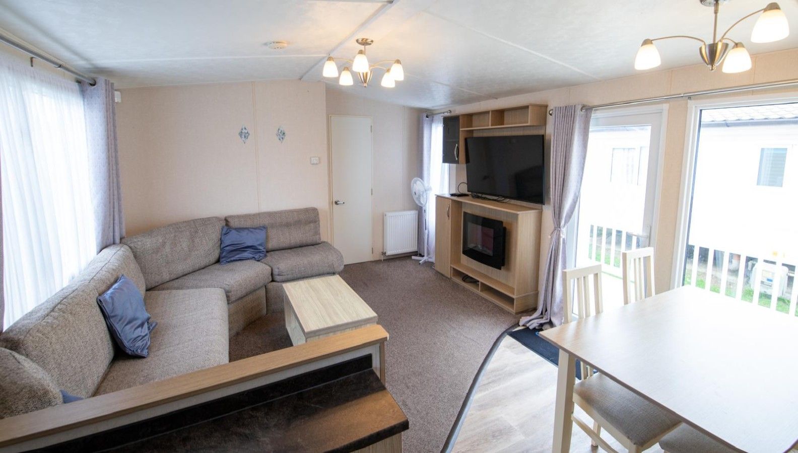 Un espace de vie compact comprenant un canapé, une petite table, un téléviseur et une cheminée.