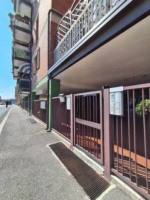 Un immeuble à plusieurs étages doté d’un parking couvert, d’une entrée sécurisée et d’une boîte aux lettres bien visible.
