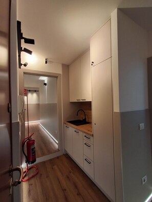 A compact kitchen with a sink, cabinets, and a fire extinguisher. - Porta Fiera | Room 4 (Verona)