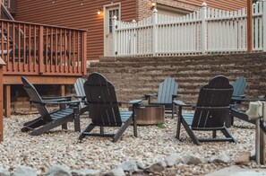 An outdoor seating area with Adirondack chairs and a fire pit. - Bigfoot's Hideout - Cabin-Game Room Sleeps 10 (Logan)