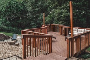 Eine Holzterrasse mit integriertem Sitzbereich, umgeben von einer natürlichen Landschaft.