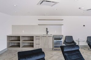A modern interior with a kitchenette, seating area, and a ceiling with recessed lighting. - The Silhouette Nest | 2BR+2BA | Pool&Sauna (Kelowna)