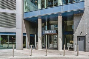 A modern building entrance with a sign reading 'AQUA II' and a glass facade. - The Silhouette Nest | 2BR+2BA | Pool&Sauna (Kelowna)