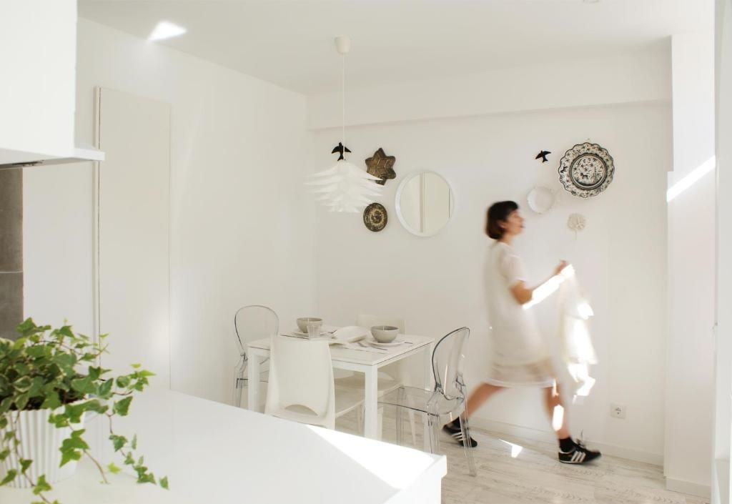 Un interior moderno con comedor, paredes blancas y decoración mural.