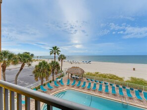 A pool area with lounge chairs and a view of the beach. - Beachfront | Pool | Walk to John's Pass - Sandy Shores #202 (Madeira  Beach)