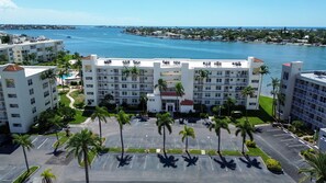A multi-story hotel with a parking lot, palm trees, and a view of the water. - Pool, Hot Tub, Beach Area | Intracoastal Views | Bahia Vista 529 - Bahia Breeze (St. Petersburg)