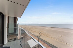 Blick auf den Strand vom Balkon aus, bewölkter Himmel.