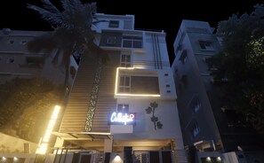 A multi-story building with a modern design, featuring a prominent illuminated sign on the front. - Super Townhouse RCC Pristine (Hyderabad)