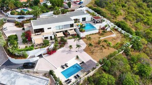 A modern resort with multiple swimming pools, outdoor seating areas, and lush landscaping. - Casa Pasha - Apartment Tiara - Jan Thiel (Jan Thiel)