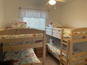A bunk bed room with floral bedding, a window with blinds, and a ceiling fan. - Close To Disney Condo 3 Bed / 2 Bath 3 Bedroom Condo (Kissimmee)