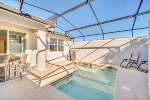 A swimming pool with a covered patio area, including a table and chairs, and a sunshade structure. - 5 Bed/4.5 Bath Town House Champions Gate Resort! 5 Bedroom Villa (Davenport)