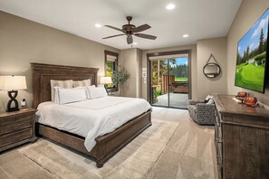 A bedroom with a large bed, a ceiling fan, a nightstand with a lamp, a dresser, and a television on the wall. - Private Pool! Stunning View Overlooking Hole #4 on the Rope Rider Golf Course (Cle Elum)