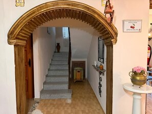 Eine Treppe führt zu einer zweiten Etage, gekrönt von einem verzierten Bogen.