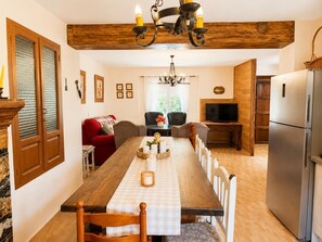 Ein Essbereich mit einem Holztisch, Stühlen und einer Pendelleuchte.