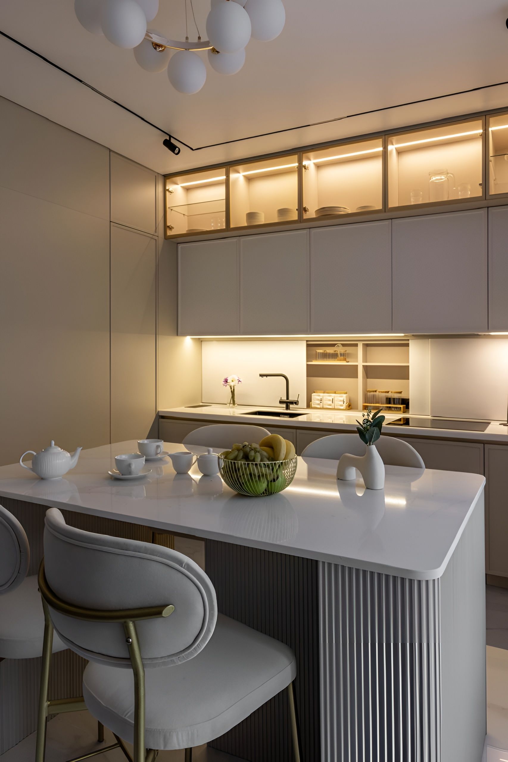 Een moderne keuken met een centraal eiland, witte kasten en een ingebouwde oven.