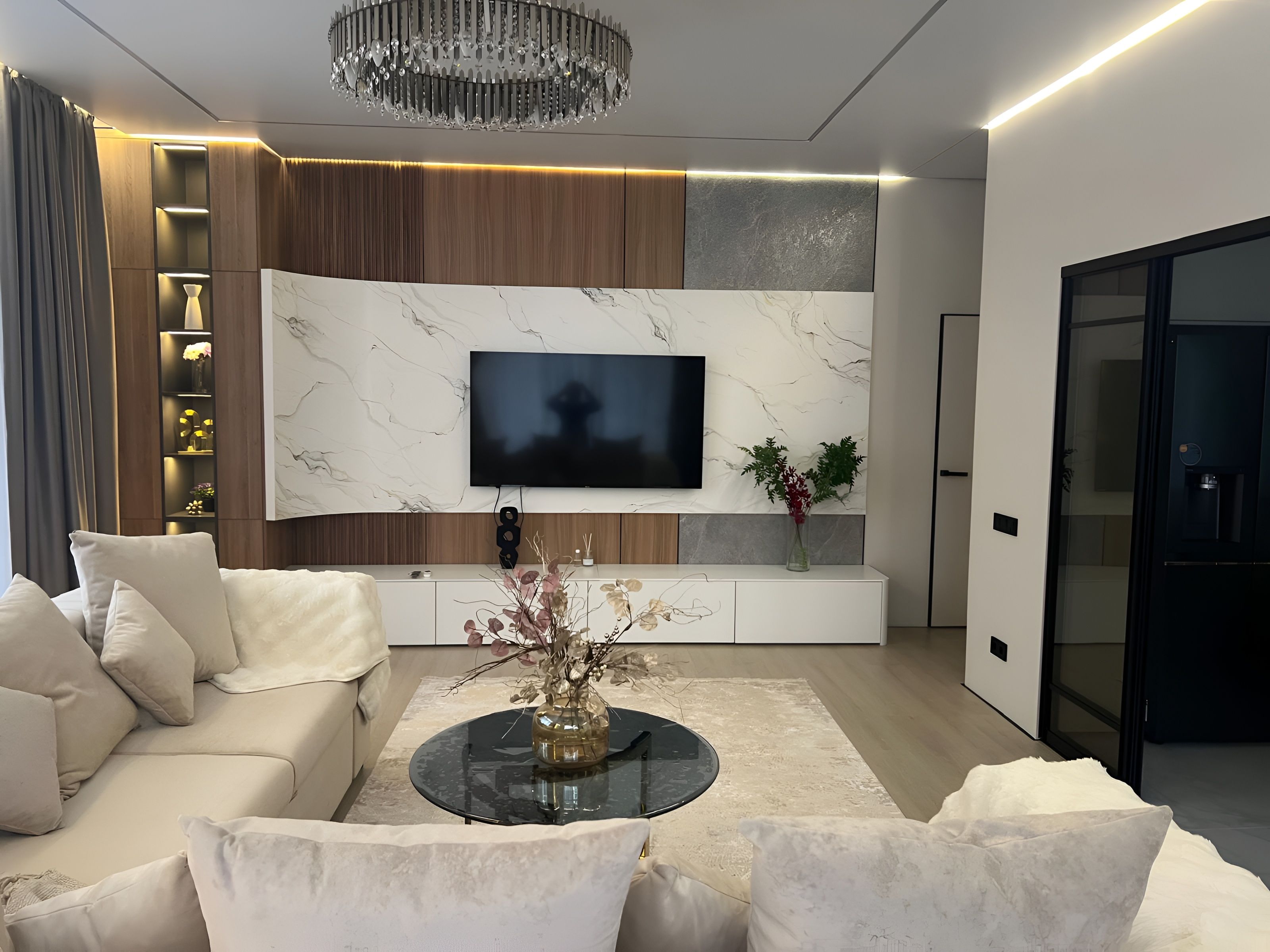 A modern living room with a sofa, a coffee table, a TV, and a decorative vase.