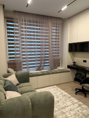 Ein moderner Büroraum mit einem grünen Sofa, einem Schreibtisch und einem Stuhl.