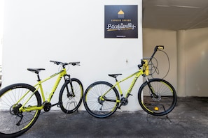 Two bicycles parked against a wall with a sign above them. - Hotiday Fuerteventura Seafront (Antigua)