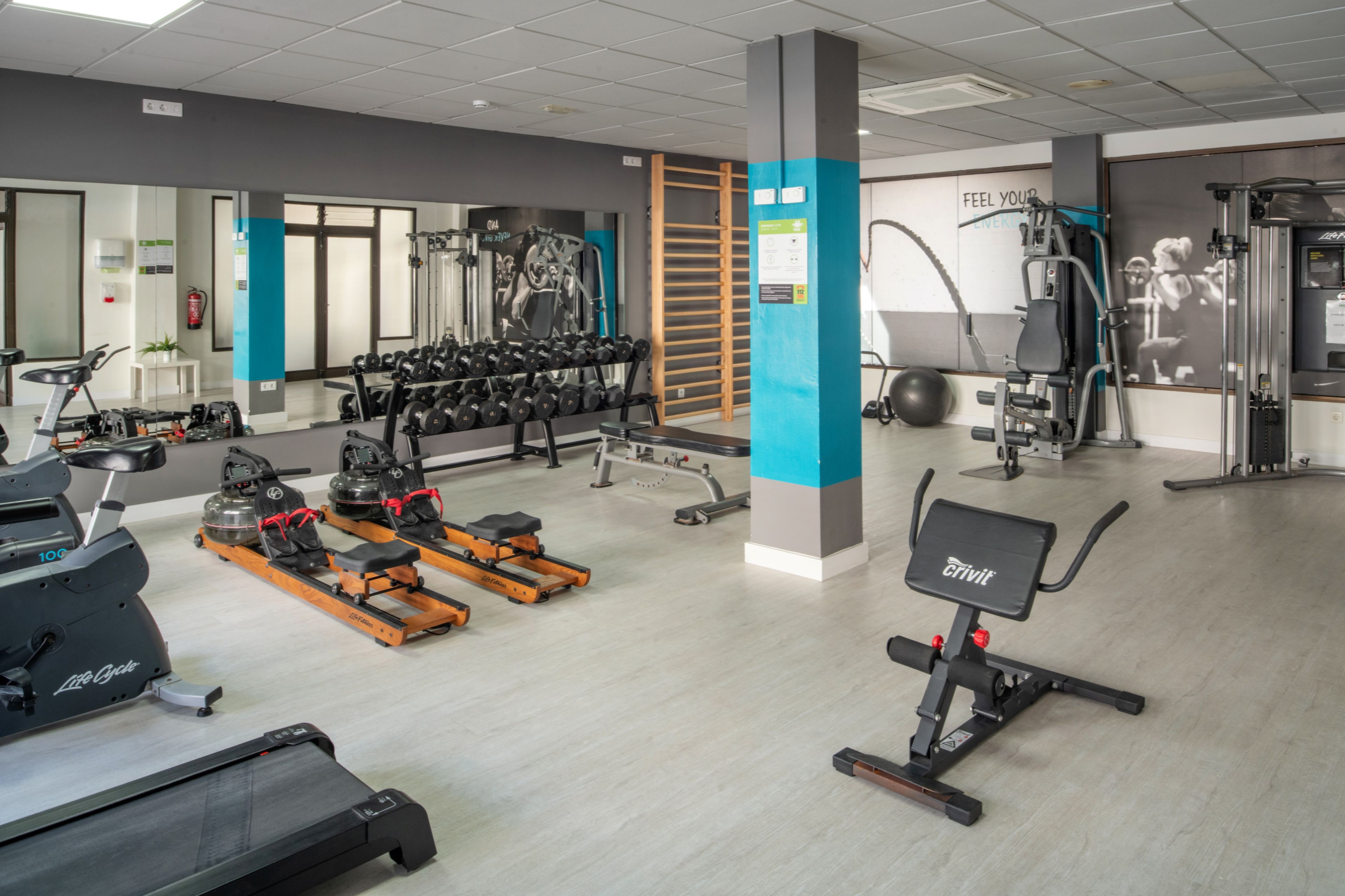 A gym with cardio equipment, weight machines, and free weights.