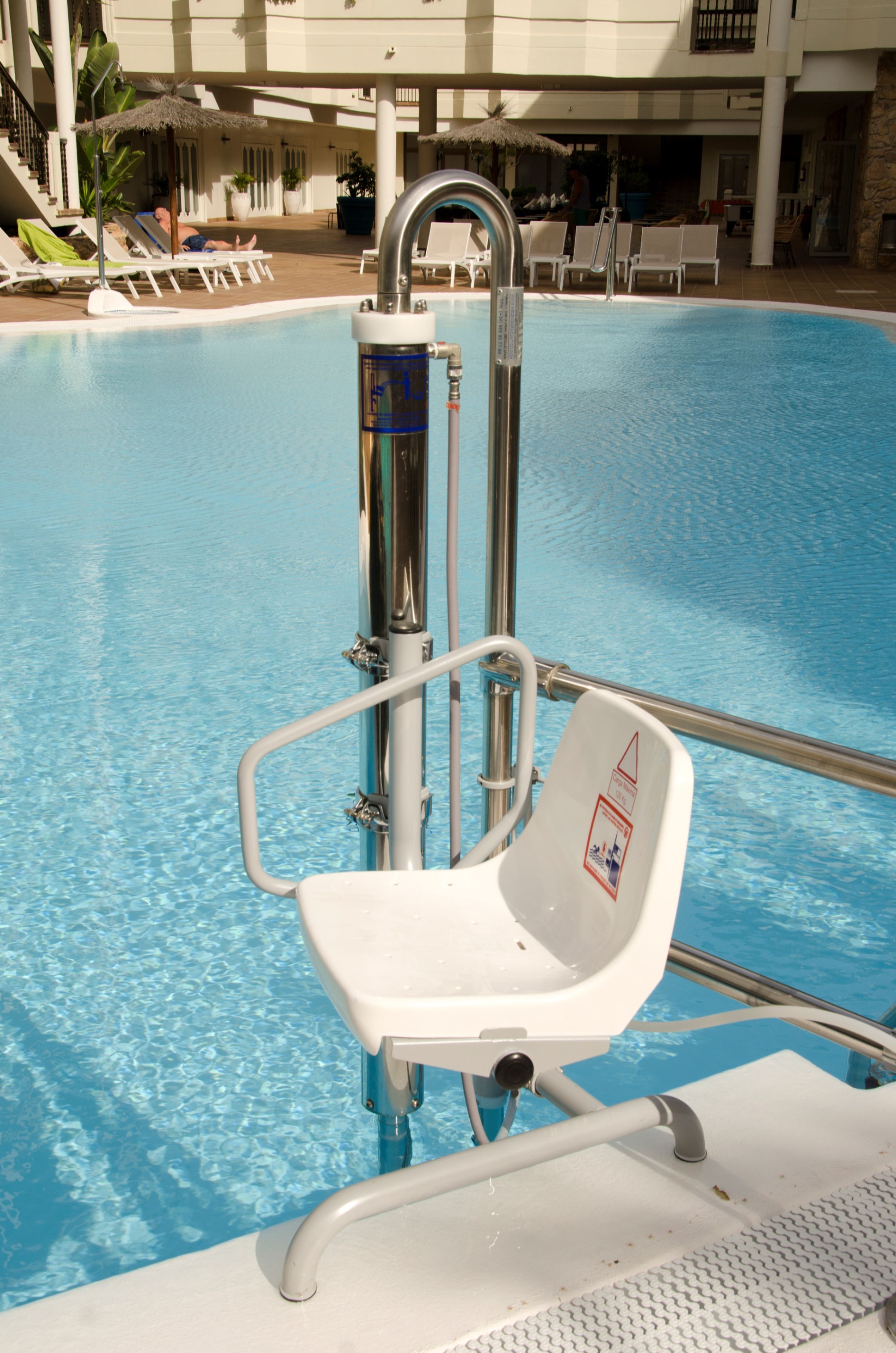 A pool with a lifeguard chair and a metal pole.
