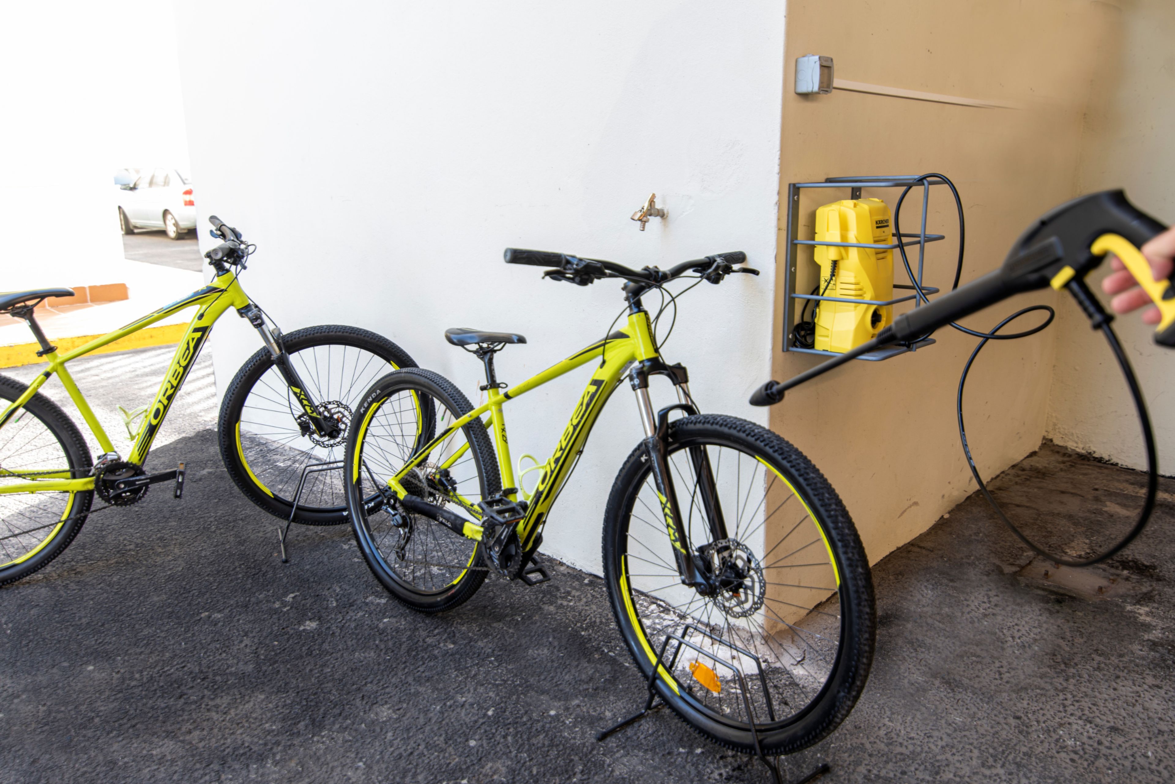 Een fiets die binnen staat geparkeerd, met een gele schoonmaaktool in de buurt.