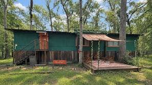 A rustic cabin with a wooden deck and a staircase leading to a porch. - Suwannee River Canopy Cabin - 5 Min Walk to Gornto Springs - Wetland Bridge View (Old Town)