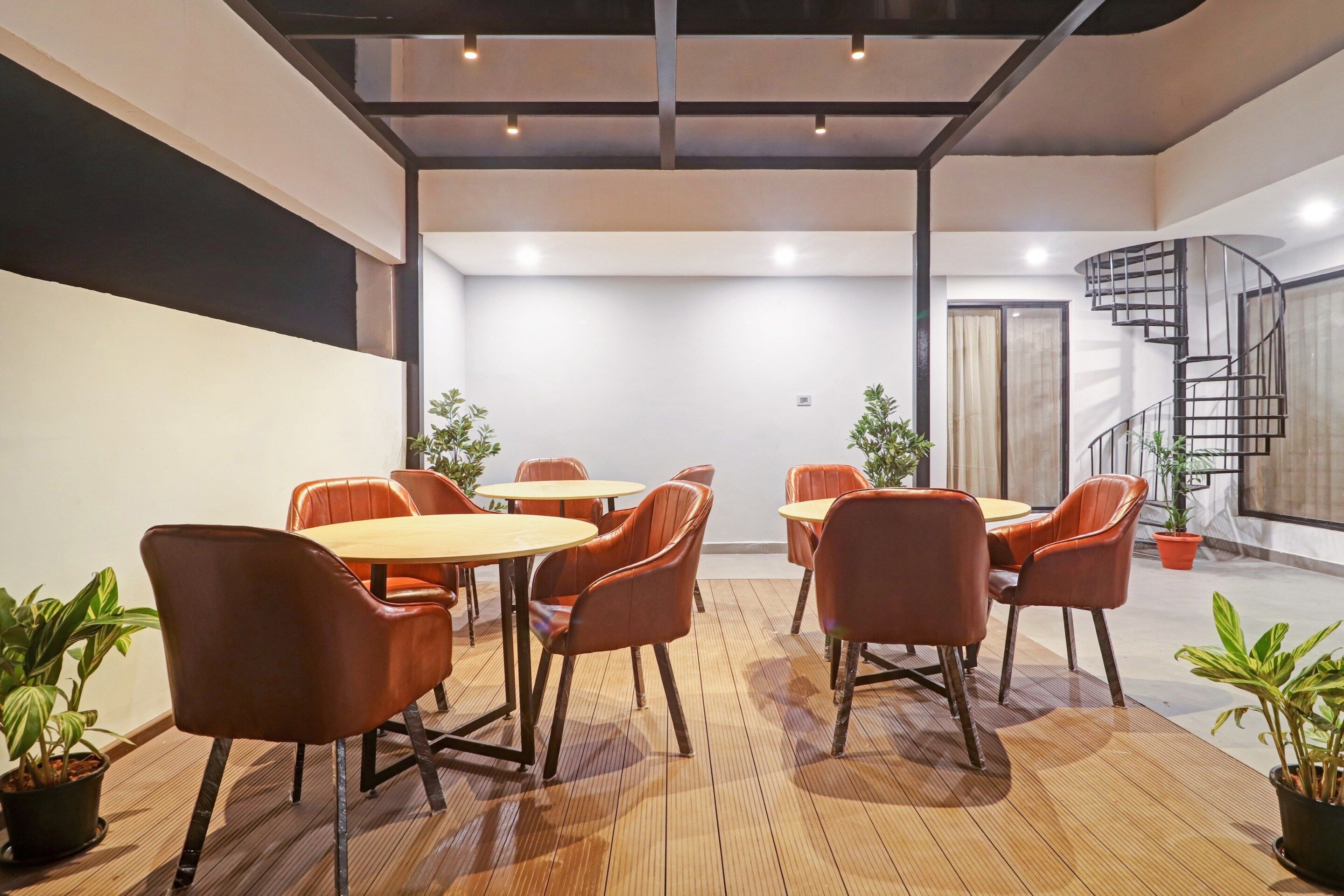 Une salle de conférence dotée d’un plancher en bois, de fauteuils en cuir et de tables.