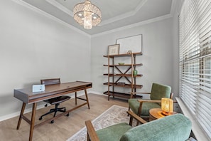 Ein moderner Arbeitsraum mit Schreibtisch, Stuhl, Regale und einer dekorativen Lampe.