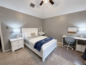 A bedroom with a bed, bedside tables, a desk, and a chair. - 30 Day Rental | Spacious Home with Private Pool | Near Grapevine Lake (Flower Mound)