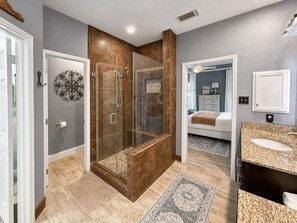Une salle de bain moderne avec une douche à parois de verre, un meuble-lavabo et un dressing.