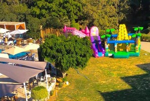 An outdoor area with a pool, umbrellas, and a colorful inflatable play structure. - Phebus Hôtel  Gammarth  (Gammarth)