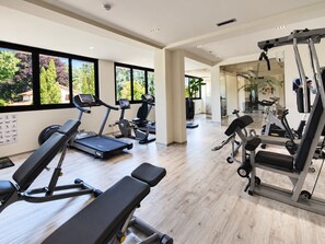A gym with treadmills, elliptical machines, and weightlifting equipment. - Hotiday Dormelletto Lago (Borgomanero)
