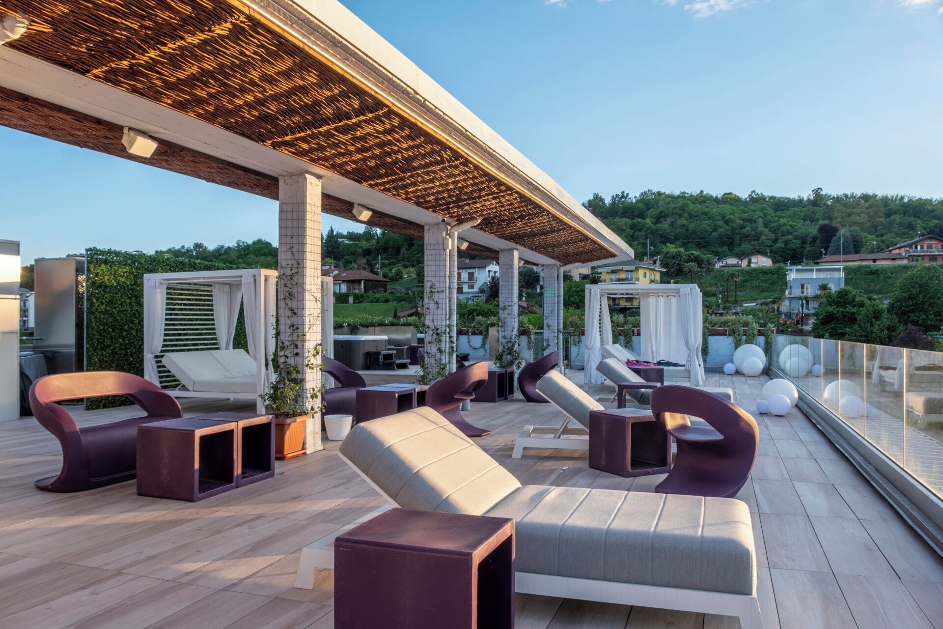 An outdoor seating area with modern furniture and a view of a hillside.