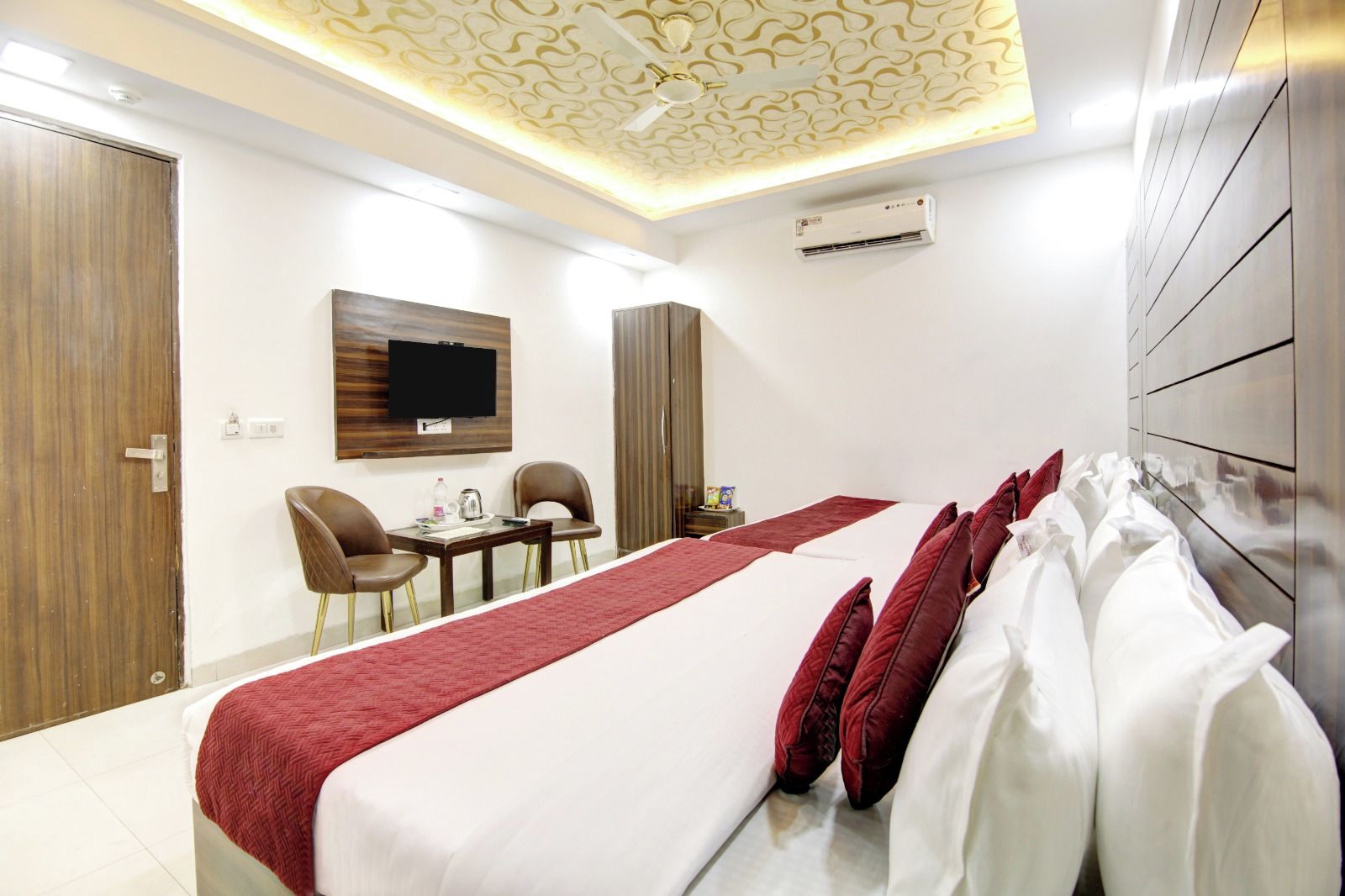 Une chambre d’hôtel avec un lit, une télévision, un bureau et des chaises.